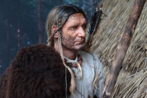 Figura rzeźby mężczyzny w chacie megalitycznej
